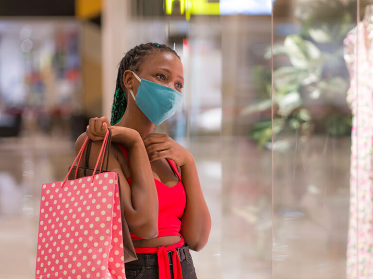 Retailers and mask policies, article by Celia Schnupp of Perez Morris, young woman shopping for clothes with a mask